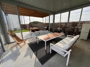 a screened in porch with a table and chairs at VILLA Seamu 九十九里 家族と愛犬で楽しむサウナとプール ガラス貼りBBQルーム付き高級ガーデンヴィラ in Kujukuri
