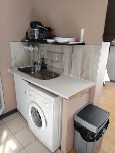 een keuken met een wasmachine en een wastafel bij Rustig by die See in Bettyʼs Bay +1 foto