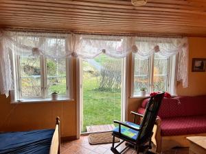 a room with a window with a chair and a couch at Sweet guest house with a view in Sävsjö