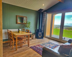 a dining room with a table and a fireplace at Under the Oak Glamping in Caerphilly +24 photos