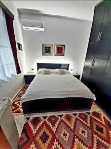 a bedroom with a large bed and a rug at Dalipi's Guest House in Gjirokastër +29 photos