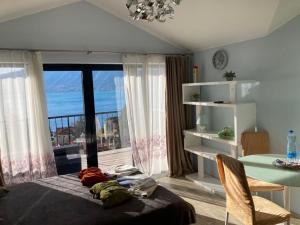 a bedroom with a bed and a table and a balcony at Apartments FANTASY in Kotor