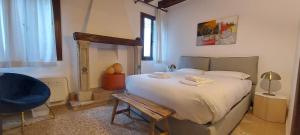 a bedroom with a large bed and a blue chair at Domus Estia in Venice +14 photos