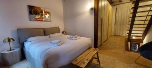 a bedroom with a large white bed with a wooden bench at Domus Estia in Venice