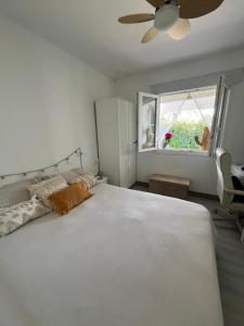 a bedroom with a large white bed and a window at Menorca Palm Villa in Cala en Blanes +29 photos