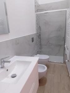 a white bathroom with a sink and a toilet at Palazzo Annarita in Brindisi +16 photos