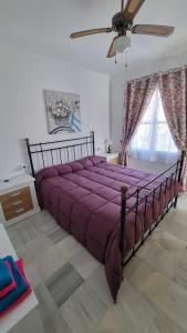 ein großes lila Bett in einem Schlafzimmer mit einer Decke in der Unterkunft Vera Natura isleta nudista in Vera