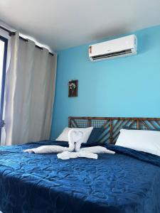 a blue bedroom with a bed with towels on it at Eden One in Ilhéus +37 photos
