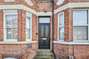 a black door on the side of a brick building at Appleton House in Newark-on-Trent