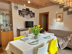ein Esszimmer mit einem weißen Tisch und gelben Stühlen in der Unterkunft Haus Martina by ISA AGENTUR in Bad Kleinkirchheim