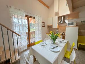 eine Küche mit einem weißen Tisch und gelben Stühlen in der Unterkunft Haus Martina by ISA AGENTUR in Bad Kleinkirchheim