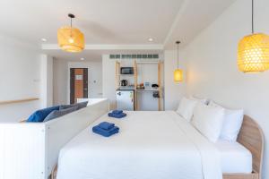 a bedroom with a large white bed and a couch at De Blue Door, Hatyai in Hat Yai