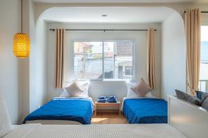 a bedroom with two beds and a window at De Blue Door, Hatyai in Hat Yai +70 photos