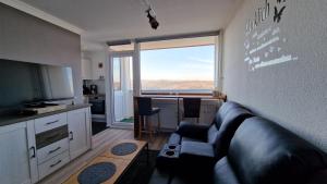 een woonkamer met een bank en een groot raam bij Harztraum in Altenau