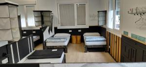 a small room with three beds in a room at Albergue A ROTONDA in Redondela +8 photos