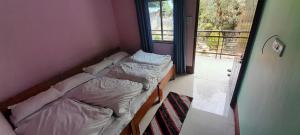 due letti in una piccola stanza con una finestra di Shivaay Camp And Resort Guptkashi a Ukhimath