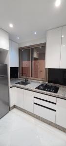 a white kitchen with a sink and a stove at alhoceima egara miniI in Al Hoceïma