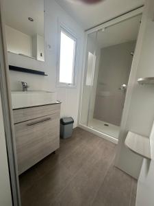 塞里尼昂Mobil Home SIBLU VALRAS PLAGE的带水槽和淋浴的白色浴室