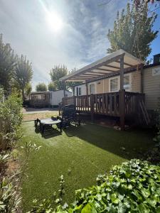 塞里尼昂Mobil Home SIBLU VALRAS PLAGE的庭院,带甲板,长凳和房子