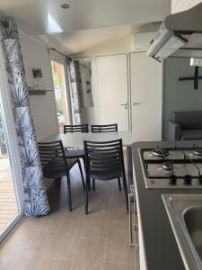 塞里尼昂Mobil Home SIBLU VALRAS PLAGE的厨房配有桌椅和炉灶。 更多12张照片