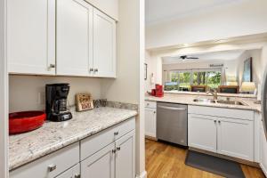 une cuisine avec des armoires blanches et un comptoir dans l'établissement 145-1 9th Hole condo by Peace Vacations, à Pawleys Island