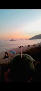 a bath tub sitting on a beach with the sunset at Apartamento a 4 minutos da praia! in Rio de Janeiro