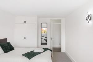 レディングにある1st Floor Flat by Reading Centre Perfect for Contractors and Long-Term Staysのベッドと鏡のある白い寝室