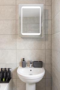 レディングにある1st Floor Flat by Reading Centre Perfect for Contractors and Long-Term Staysの洗面台と鏡のあるバスルーム