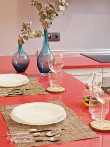 a red table with plates and wine glasses on it at Rota Beach Loft in Rota
