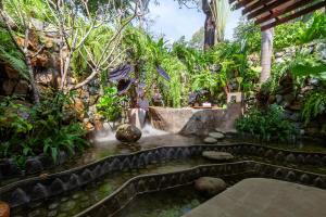 a garden with a waterfall in the middle at Lynnaya Urban River Resort in Siem Reap
