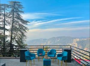 eine Sitzgruppe auf einem Balkon mit Aussicht in der Unterkunft Le Boho Shimla in Shimla