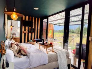 Schlafzimmer mit einem Bett und Blick auf ein Feld in der Unterkunft Romántico Glamping tipo contenedor con Jacuzzi cerca al lago de Paipa in Paipa