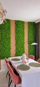 a dining room with a green wall with a table and chairs at Penthouse View Aeroport Iasi in Iaşi +164 photos