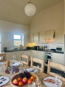 a kitchen with a table with a bowl of fruit on it at Belmullet Beach House Retreat in Belmullet