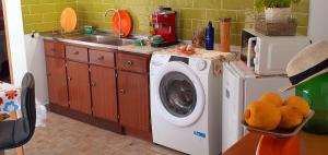 una cocina con lavadora y fregadero en Cantinho dos moinhos, en Montemor-o-Velho