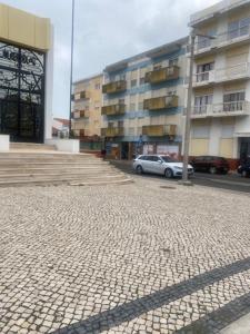a parking lot in front of a building at SwordFish City Center Apartment in Peniche