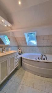 une grande salle de bain blanche avec une baignoire et un lavabo dans l'établissement Gîtes du Bois de Bontemps, à Sarlat-la-Canéda