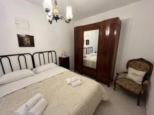 ein Schlafzimmer mit einem Bett, einem Stuhl und einem Spiegel in der Unterkunft Villa Melina in Monopoli