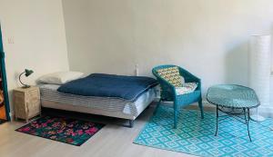 a bedroom with a bed and a chair and a table at Le petit velo rouge in Arles +5 photos