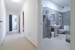 un bagno bianco con lavandino e WC di Dimora del Corso - L'Aquila a L'Aquila Altre 37 foto