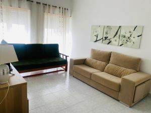 a living room with a couch and a chair at SwordFish City Center Apartment in Peniche