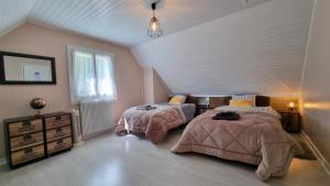 - une chambre mansardée avec 2 lits et une fenêtre dans l'établissement Gîtes du Bois de Bontemps, à Sarlat-la-Canéda