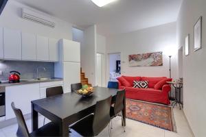 a kitchen and living room with a table and a red couch at AnticaFirenze in Florence