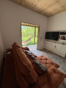 a living room with a couch and a window at Casa natureza Paraty I in Paraty