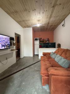 a living room with a couch and a flat screen tv at Casa natureza viva in Paraty +26 photos
