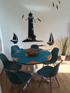 a dining room table with a lighthouse and sailboats on a wall at Apartament Kapitański Władysławowo in Władysławowo