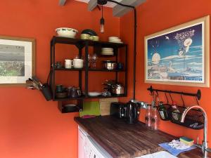 a kitchen with orange walls and a wooden counter top at Lle tawel in Llanbedrog