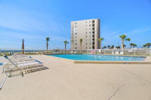 a swimming pool with chairs and a building at Perdido Sun 612 in Perdido Key