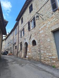 a large brick building with an alley next to it at Elunà Assisi Home in Assisi