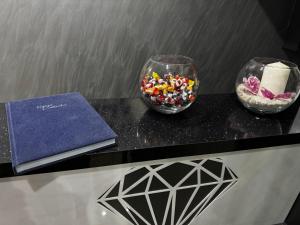 a table with two glasses of candy and a book at Apartmani Joja in Kuršumlija